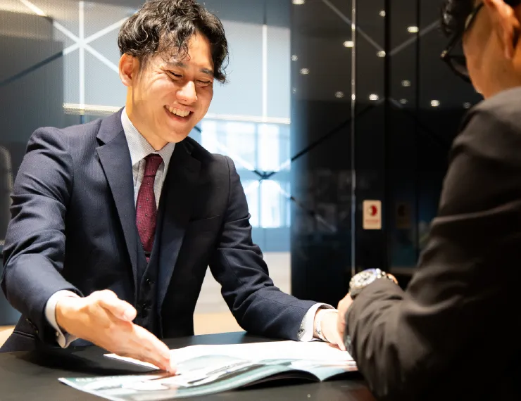 ショールームでお客様に車の提案をする営業スタッフ